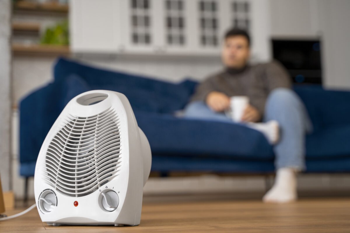 A person relaxing on a sofa with a dehumidifier running in the foreground – ideal for controlling humidity in Indian homes